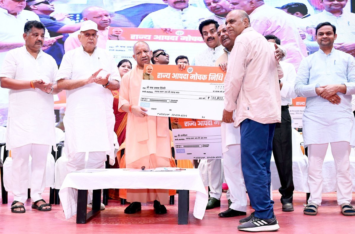 गोरखपुर में किसानों को सहायता राशि का प्रतीकात्मक चेक देते मुख्यमंत्री योगी आदित्यनाथ