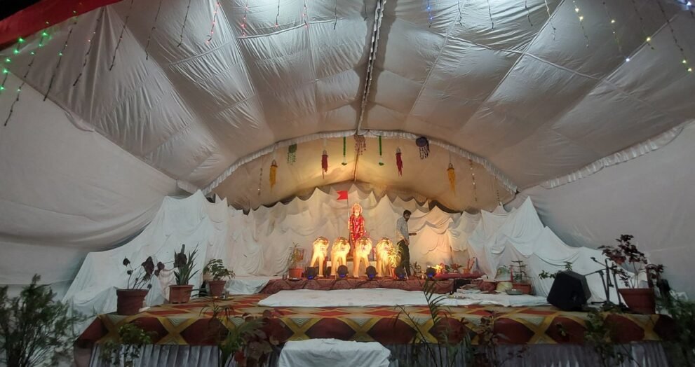 त्योहार की सजावट वाला नवरात्रि पंडाल, जिसमें दीपों से सजी देवी प्रतिमा