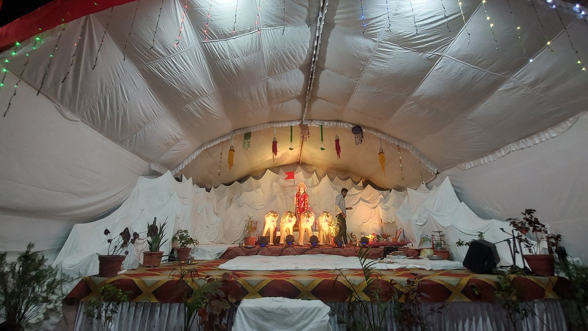 त्योहार की सजावट वाला नवरात्रि पंडाल, जिसमें दीपों से सजी देवी प्रतिमा