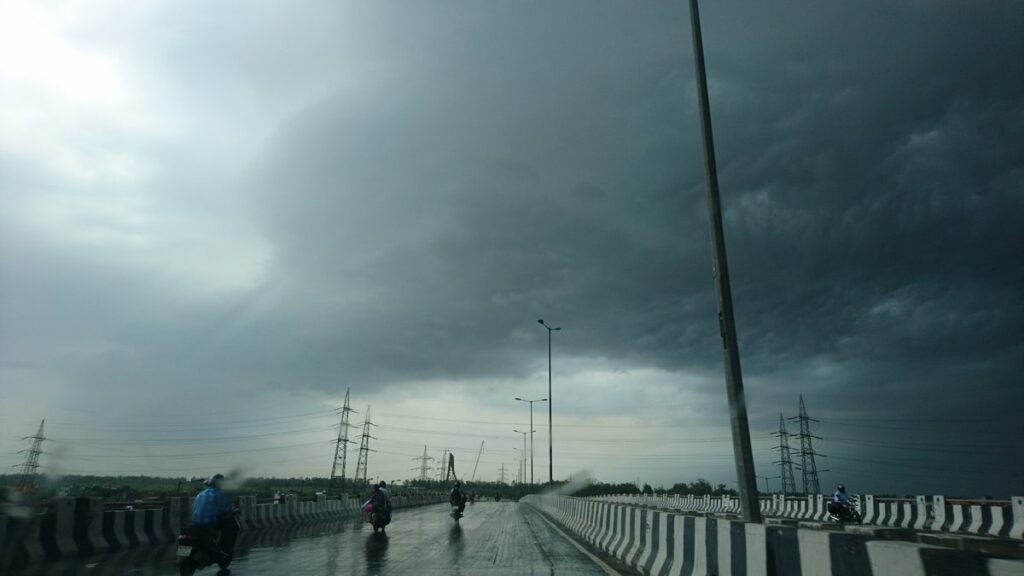 Delhi Rain: भीगी राजमार्ग पुल और तूफानी आसमान का दृश्य
