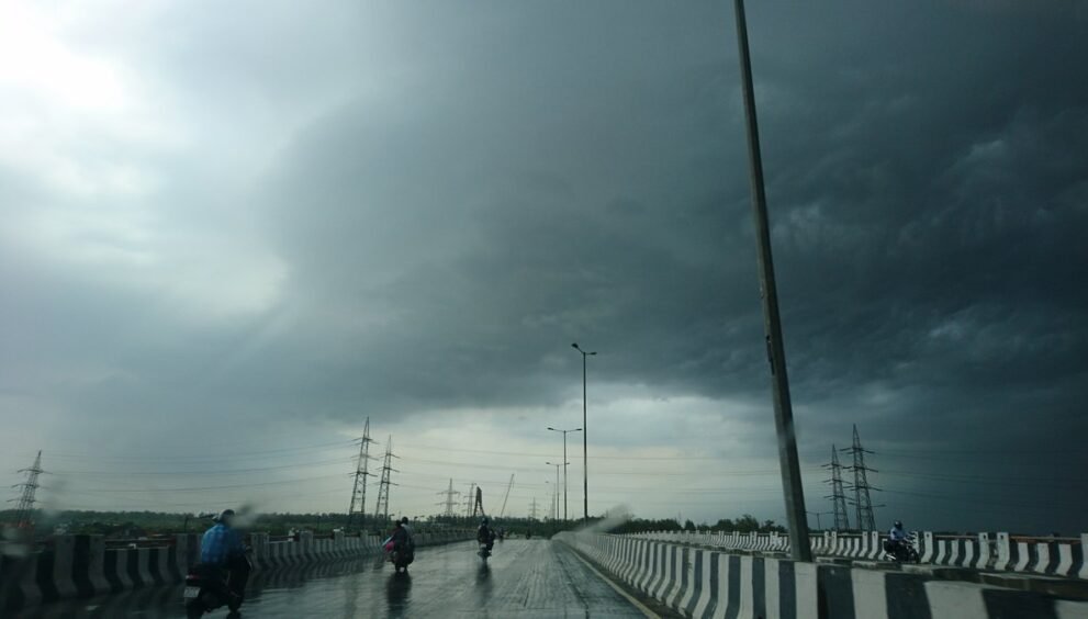 Delhi Rain: भीगी राजमार्ग पुल और तूफानी आसमान का दृश्य