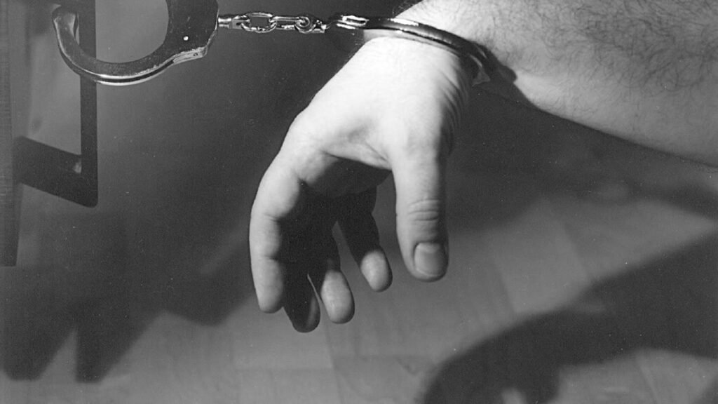 पुलिस की हथकड़ी पहने हाथ की सांकेतिक तस्वीर