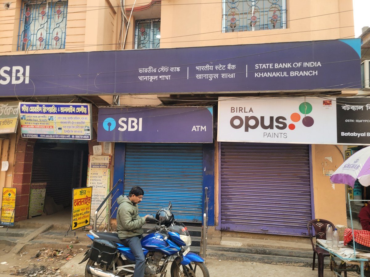 भारतीय स्टेट बैंक के ATM के बगल में गिरे हुए शटर वाली दुकानें