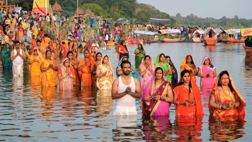 छठ पूजा पर नदी में खड़े होकर हाथ जोड़कर सूर्य की उपासना करते व्रती
