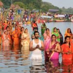 छठ पूजा पर नदी में खड़े होकर हाथ जोड़कर सूर्य की उपासना करते व्रती