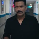 Netflix की फिल्म 'गजब रात' के एक दृश्य में काली शर्ट पहने अस्पताल के गलियारे में चलते मनोज बाजपेयी