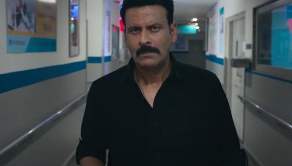 Netflix की फिल्म 'गजब रात' के एक दृश्य में काली शर्ट पहने अस्पताल के गलियारे में चलते मनोज बाजपेयी