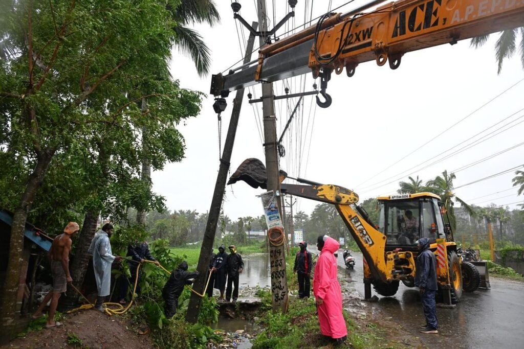 चक्रवात अर्नब के बाद आंध्र प्रदेश में गिरे बिजली के खंभे दोबारा खड़े करते कर्मचारी