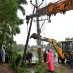 चक्रवात अर्नब के बाद आंध्र प्रदेश में गिरे बिजली के खंभे दोबारा खड़े करते कर्मचारी