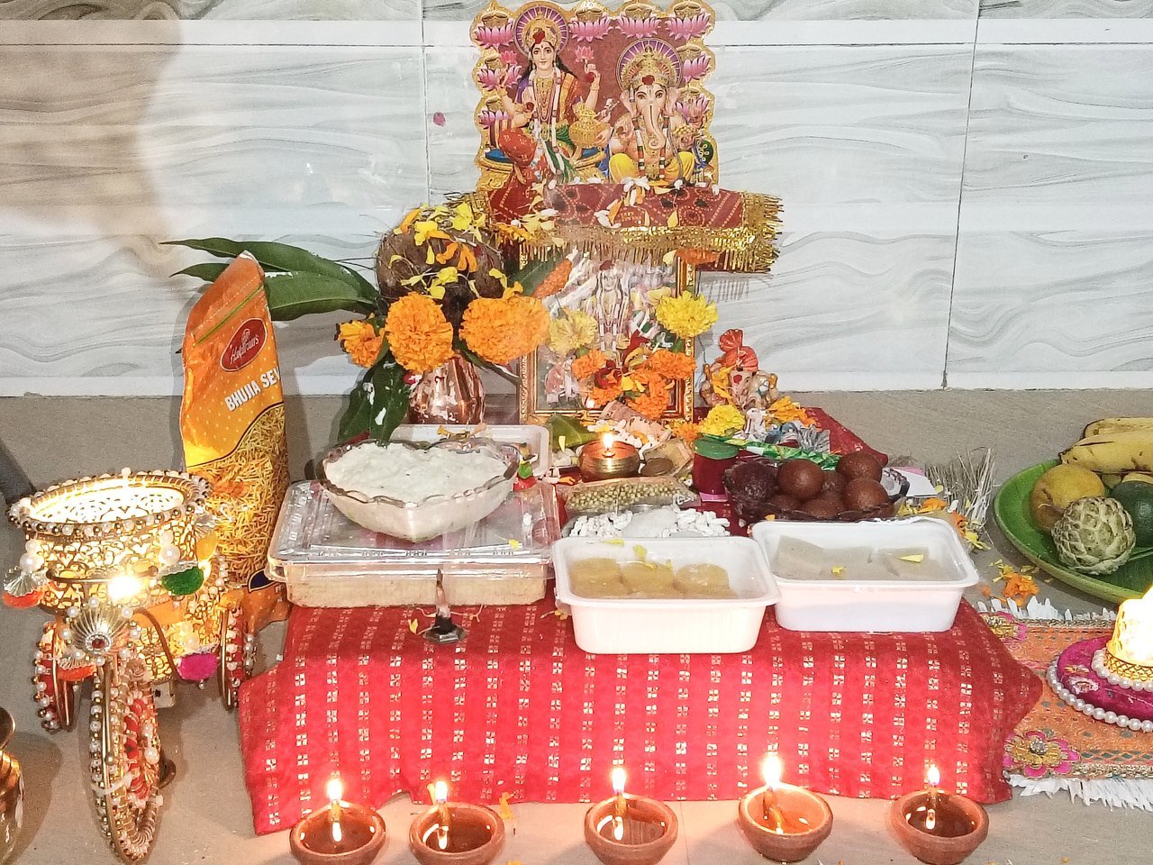 दिवाली पर घर में सजी लक्ष्मी-गणेश पूजा की चौकी, दीये और प्रसाद