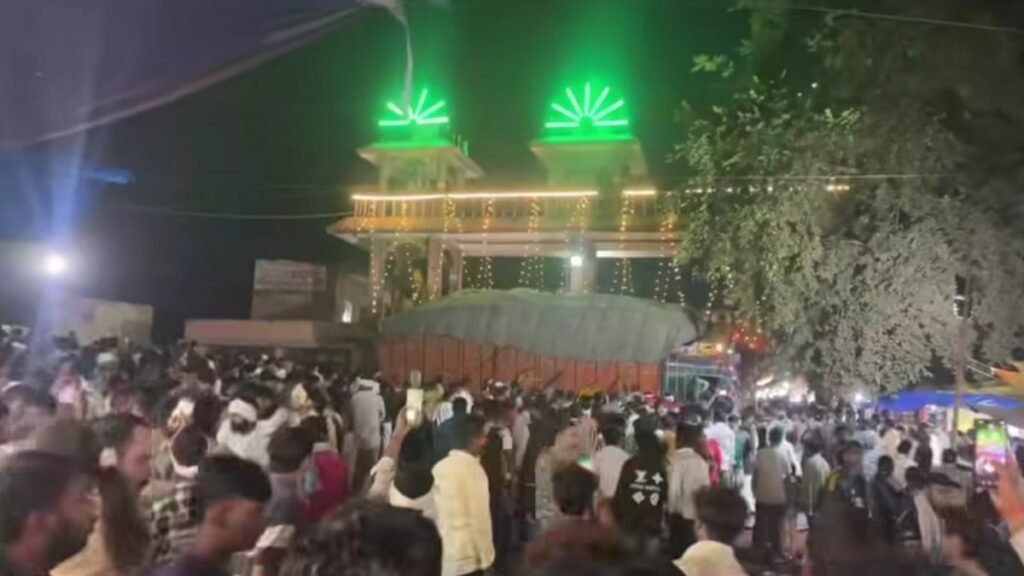 ग्वालियर में शीतला माता मंदिर के गेट के पास हादसे के बाद खड़ा धान से लदा ट्रक और जुटी भीड़