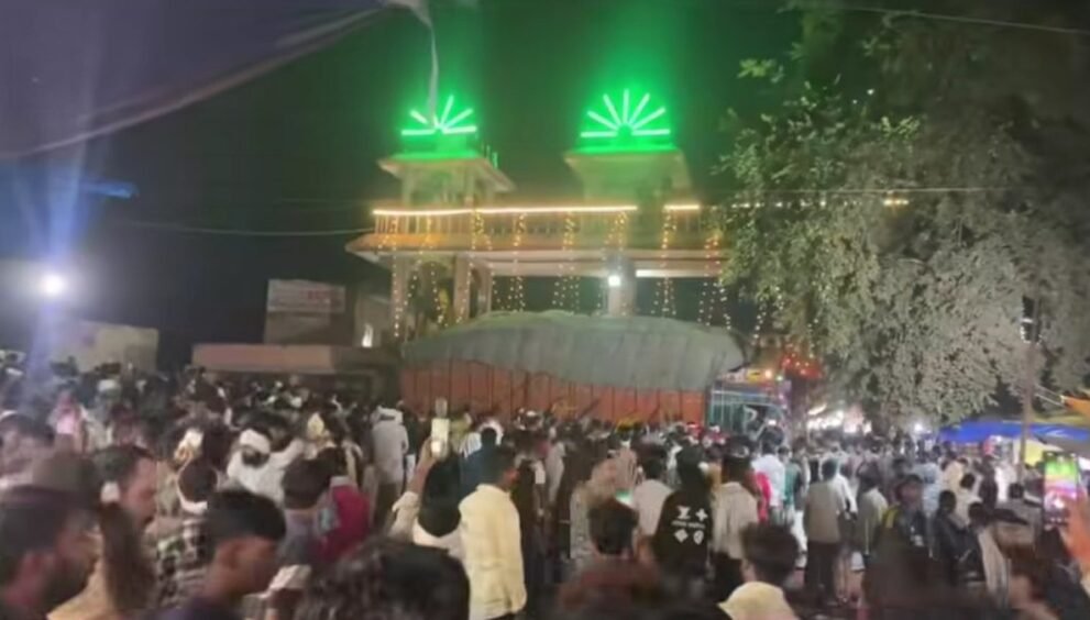 ग्वालियर में शीतला माता मंदिर के गेट के पास हादसे के बाद खड़ा धान से लदा ट्रक और जुटी भीड़