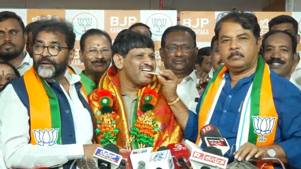 भाजपा का पटका पहने कर्नाटक विधानसभा में विपक्ष के नेता आर. अशोक माइक के सामने