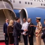 मुंबई हवाई अड्डे पर अमेरिकी विमान के पास रेड कार्पेट पर अधिकारियों से हाथ मिलाते अमेरिकी विदेश मंत्री मार्को रुबियो