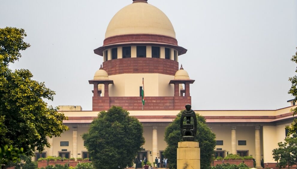 नई दिल्ली में सुप्रीम कोर्ट की इमारत का गुंबद और सामने लगा तिरंगा